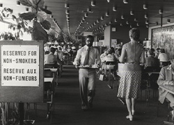 Interior view of a restaurant with a sign posted stating section: Reserved For Non-Smokers.