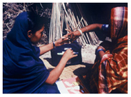 A BRAC teacher and villager measure salt