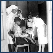 Emily Kark examines child, while the mother and a nurse observe.