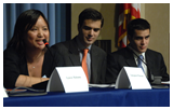 Seated panelists Tanyaporn Wansom, speaking, and Niko and Theo Milonopoulos at the exhibition opening