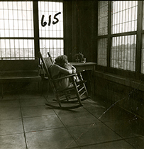 A woman sits in a rocking chair.