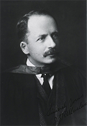 Black-and-white photo portrait of a man with written note of “Sincerely Yours J. JRMacloeod” on the lower right corner.