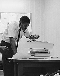 An African American doctor using a stethoscope to examine a newborn patient.