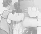 A researcher wearing a protective vest, at Food and Drug Administration's Center for Devices and Radiological Health, places a mannequin inside an x-ray machine.