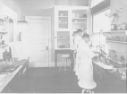 Three men in scrubs work at a table in a laboratory.