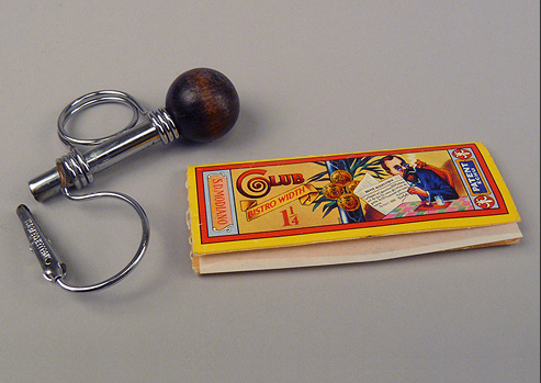 Metal roach clip and rolling paper for smoking marijuana.