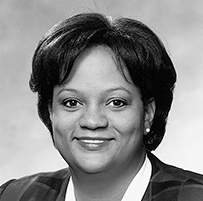 Dr. Regina Benjamin, a smiling female with short hair in professional attire.