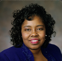 Dr. Judith Martin Cadore, an African American female in blue formal attire posing for her portrait. Inscription: Connie's by Glenn ©.