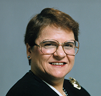 Dr. Marcella Farinelli Fierro, a White female with short hair in a dark jacket, smiling for her portrait.