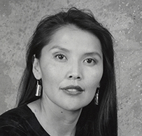 Dr. Patricia Nez-Henderson, an American Indian female with long hair wearing a dark blouse posing for her portrait.