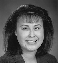 Dr. Yvette Roubideaux, an American Indian female in a suit jacket smiling for her portrait.