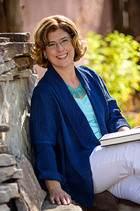 Dr. Esther M. Sternberg, a smiling White female seated outdoors posing for her portrait.