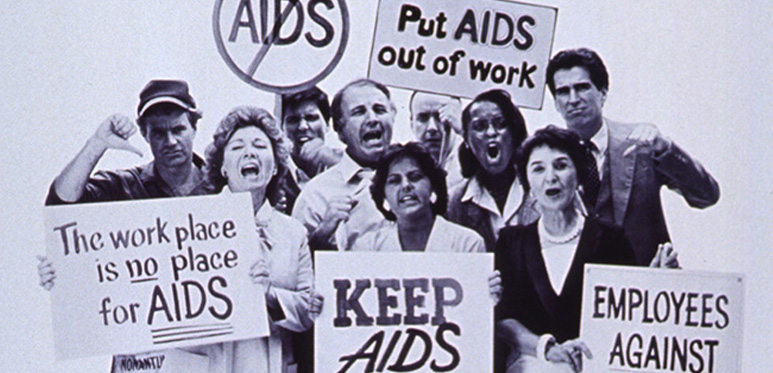 A group of people protesting hold picket signs