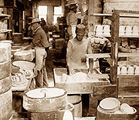 Four white men work in a factory