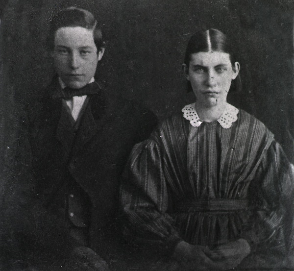 A boy and girl sitting next to other.